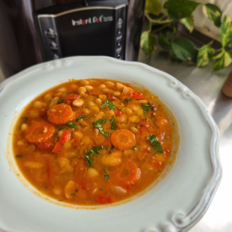 Πιάτο με υγιεινή φασολάδα, καρότα και φρέσκο μαϊντανό, σερβιρισμένο μπροστά από μια συσκευή Instant Pot.